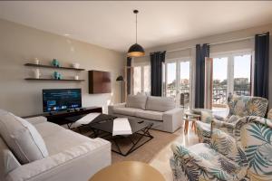 a living room with white furniture and a tv at Luxury Stays in New Marina, El Gouna in Hurghada +22 photos