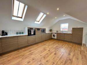 a large kitchen with wooden floors and skylights at Central duplex Apt in Leamington Spa in Leamington Spa +23 photos