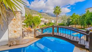 een brug over een zwembad met een berg op de achtergrond bij Villa with Garden Shared Pool – 4 Min from Beach in Kalkan
