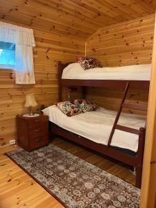 two bunk beds in a log cabin with a window at Storevatn Fritid in Masfjorden
