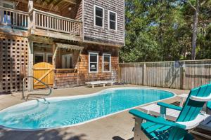 una piscina con dos sillas y una casa en 6080 - Kokomo, en Nags Head