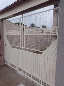 ein offenes Garagentor mit einem weißen Zaun in der Unterkunft Lar Aconchego in Palmas