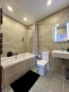a bathroom with a tub and a toilet and a sink at Central duplex Apt in Leamington Spa in Leamington Spa