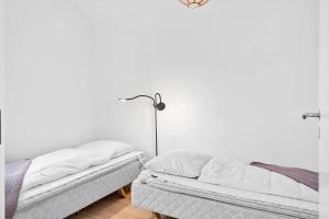 a bedroom with two beds and a lamp at 70894-Ulfborg-Skolegade-15-Lejl-6 in Thorsminde