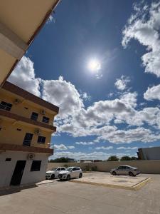 two cars parked in a parking lot next to a building at Pousada Amorim in Frecheirinha