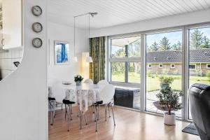a white dining room with a table and chairs at 30140-Ulfborg-Valmuevej-290 in Vang