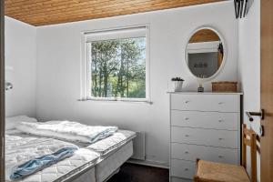 a bedroom with a bed and a mirror and a dresser at 30140-Ulfborg-Valmuevej-290 in Vang