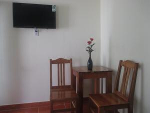 une chambre avec deux chaises et une table avec un vase et des fleurs. dans l'établissement Manh Duyen Garden Homestay, à Duong Dong