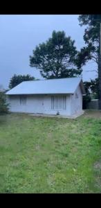 Un gran granero blanco en un campo de hierba en Cabaña en gesell, en Villa Gesell 10 fotos más