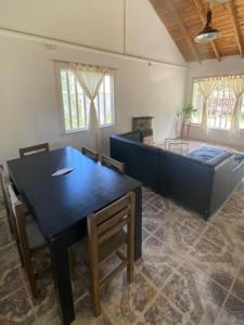 sala de estar con mesa de comedor y cama en Cabaña en gesell, en Villa Gesell