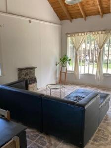 Una sala de estar con un sofá azul y una chimenea. en Cabaña en gesell, en Villa Gesell