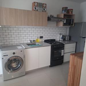 a kitchen with a washing machine and a washer at LaFaldaStayBahia - Confort y Bienestar garantizado in Bahía Blanca +3 photos
