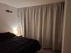 a bedroom with a bed and a white curtain at LaFaldaStayBahia - Confort y Bienestar garantizado in Bahía Blanca