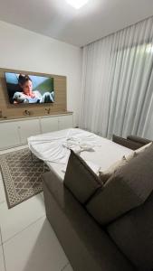 a bedroom with a bed and a flat screen tv at ILOA Apto 02 quartos H in Barra de São Miguel +45 photos