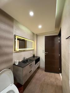 a bathroom with a sink and a toilet and a mirror at Elysium Premium Centaurus View in Islamabad +124 photos