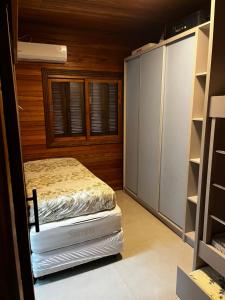 a bedroom with a bed and a closet at Chalé Rossa in Xangri-lá
