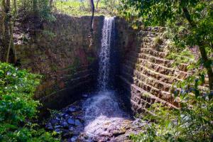 a waterfall in the middle of a brick wall at Hotel Fazenda Vale Alvorada in Toledo