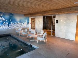 a patio with chairs and a table and a swimming pool at Appartement de luxe les Arcs 4 chambres skis aux pieds in Arc 1800