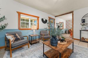 a living room with two chairs and a table at Orange Blossom Hideaway - Hot Tub & Fire Pit in Fredericksburg