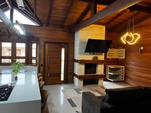 a living room with a couch and a tv at Chalé Rossa in Xangri-lá