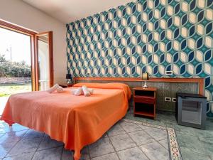 a bedroom with an orange bed and a wall at Hotel Lo Smeraldo in Ventotene +40 photos