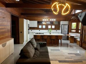 a living room with a couch and a kitchen at Chalé Rossa in Xangri-lá
