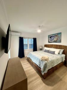 a bedroom with a bed and a flat screen tv at Townhouse Villa 2 The Village at Hoopers Bay in New Providence Island +27 photos