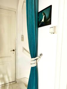 a blue curtain hanging on a door with a tv at Casa di Kola in Zutphen