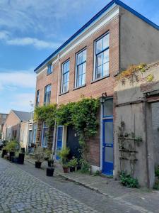 a brick building with blue doors on a street at Casa di Kola in Zutphen