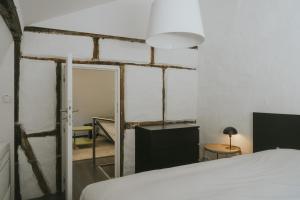 a bedroom with a white bed and a brick wall at 2 bedrooms triplex in historic heart of Liege in Liège