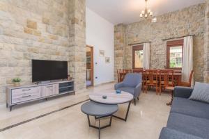 Al QannābahにあるBeit Salima - 3 Bedroom House with Pool & Terraceのテレビ、ソファ、テーブルのあるリビングルーム