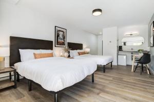 a bedroom with two beds and a desk in it at Gateway Suites Escape to the Rocky Mountains in Canmore