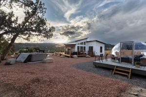 una casa con una cupola di vetro in un cortile di Sky Dome Hot Tub Climbing Wall Hammock Tents EV a Glendale