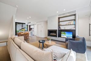 a living room with a couch and a table at Luxury 3 storey residence in Melbourne