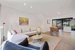 a living room with a couch and a table at Luxury 3 storey residence in Melbourne