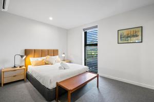a bedroom with a bed and a wooden table at Luxury 3 storey residence in Melbourne +26 photos