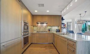 ロサンゼルスにあるSuperb Two Bedroom Condo in Santa Monicaの大きなキッチン(木製キャビネット、ステンレス製の電化製品付)