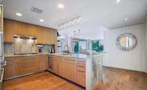 ロサンゼルスにあるSuperb Two Bedroom Condo in Santa Monicaの大きなキッチン(木製キャビネット、カウンタートップ付)