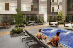 Dos personas sentadas en una piscina en un edificio. en Protea Hotel by Marriott Kinshasa, en Kinshasa