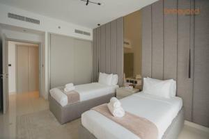 a hotel room with two beds with white sheets at Exclusive Home with Private Beach in Dubai +29 photos