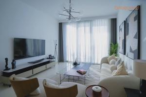a living room with a white couch and a tv at Exclusive Home with Private Beach in Dubai