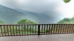 una terraza de madera con vistas a la montaña en Alishan Fenqihu Green Land Homestay, en Guanghua