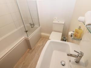 a bathroom with a white sink and a toilet at Kirkgate Cottage in Cockermouth +13 photos