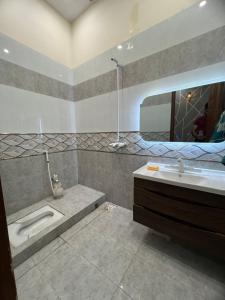 a bathroom with a sink and a tub and a mirror at Luxury Premium just Families in Faisalabad