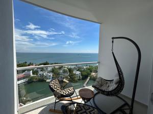 ein Balkon mit zwei Stühlen und Blick auf das Meer in der Unterkunft exclusivo apto 112 sierra beach by vacationvip in Playa Bello Horizonte