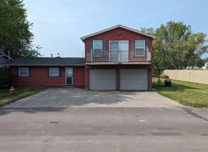 une maison rouge avec un balcon et une allée. dans l'établissement Catch on the Canal - Waterfront Getaway Near Casino, Dining & Entertainment, à Standish