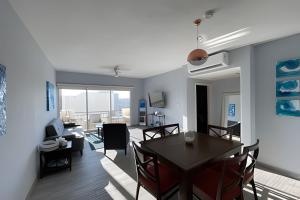 a dining room and living room with a table and chairs at Villa Dorada in Cabo San Lucas