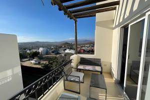 a balcony with chairs and a view of the city at Villa Dorada in Cabo San Lucas