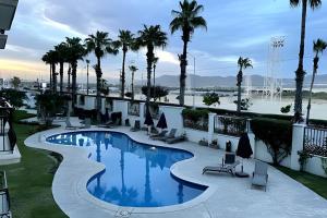 a pool on the roof of a hotel with palm trees at Puerta Cabos Village in Cabo San Lucas