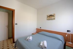 Un dormitorio con una cama con dos pantuflas encima. en PARISI - Sirmione Punta Gro', en Sirmione 20 fotos más